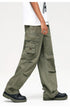 Side view of model wearing olive cargo pants with detailed side pockets and D-ring hardware, paired with black platform shoes