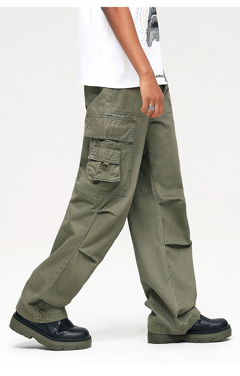 Side view of model wearing olive cargo pants with detailed side pockets and D-ring hardware, paired with black platform shoes