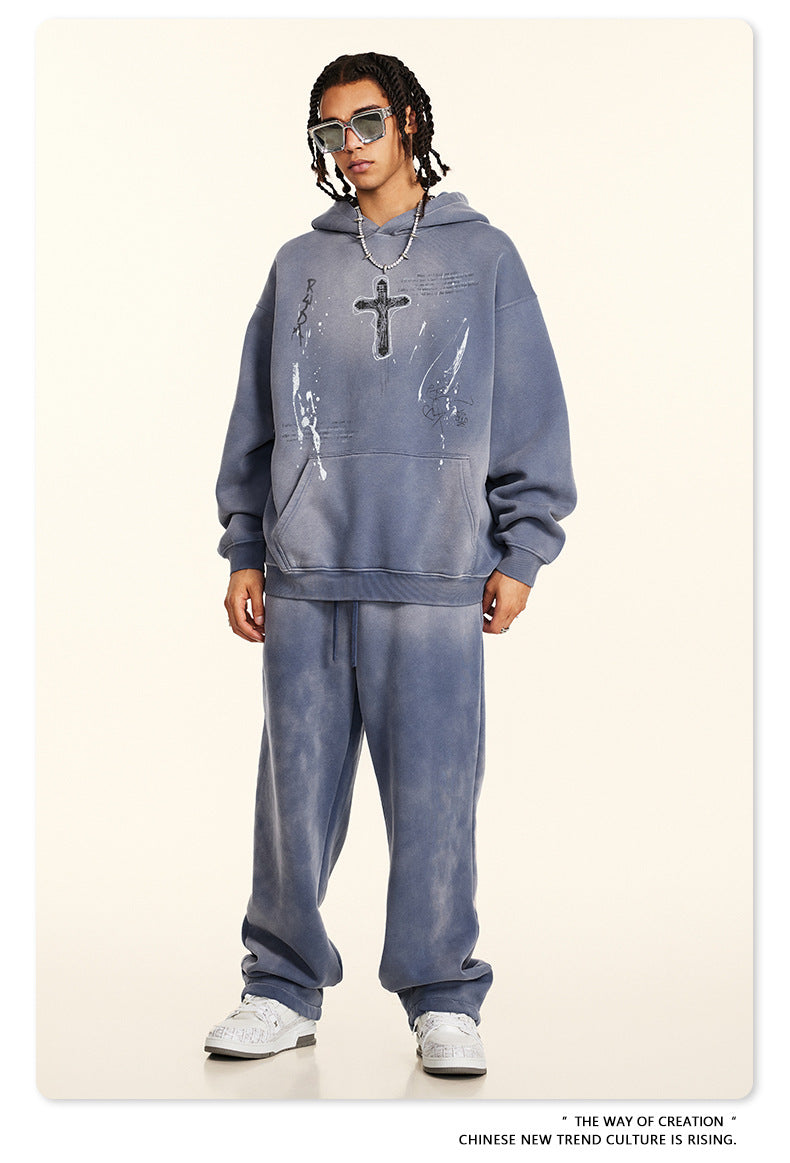 Full-length shot of gray graphic hoodie and sweatpants set, styled with white sneakers and silver chain necklace