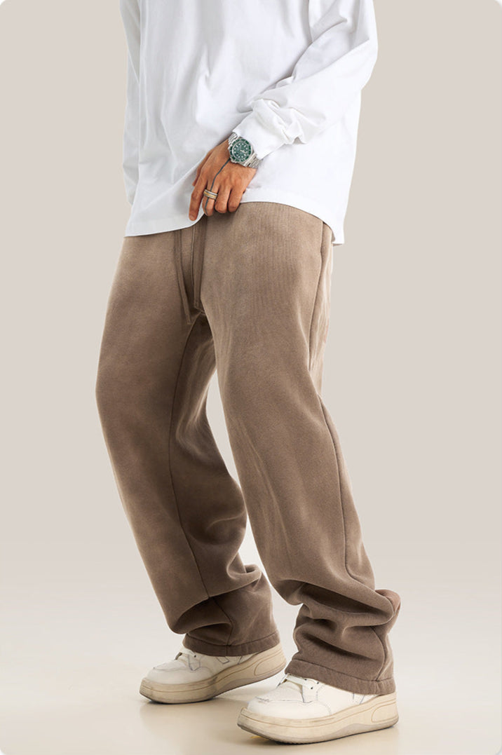 Side view of taupe wide-leg sweatpants with elastic waistband paired with white sweatshirt and sneakers