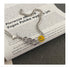 Close-up detail of Cuban chain necklace with smiley charm and crystal snake accent displayed on text page, showing texture and finish of metal