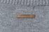 Tan leather label reading 'airhood' stitched onto grey knit fabric.