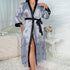 Silver/gray satin robe with black trim, printed with handwritten hearts and "love" text, worn open with side slit on white textured bed