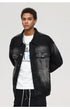 Close-up shot of a male model in a black washed denim jacket over a white graphic T-shirt and cargo pants