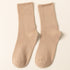 A pair of beige ribbed crew socks displayed flat against cream background showing texture and full length