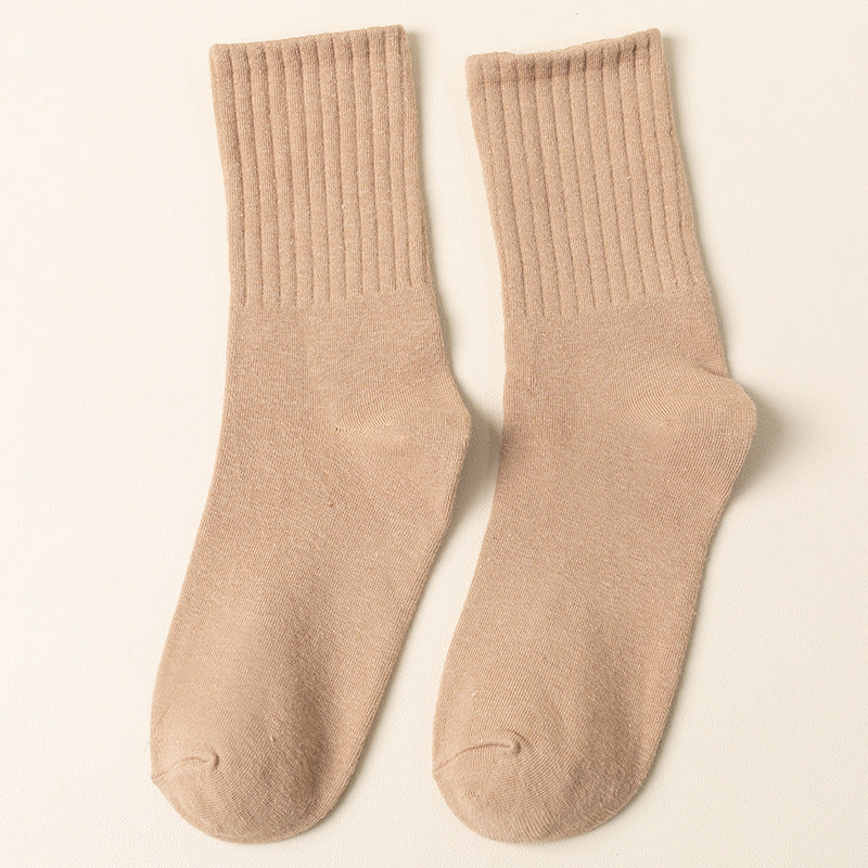 A pair of beige ribbed crew socks displayed flat against cream background showing texture and full length