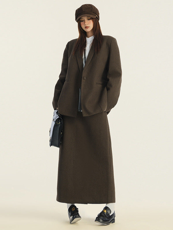 Dark brown wool blazer and maxi skirt set styled with white top, newsboy cap and black loafers