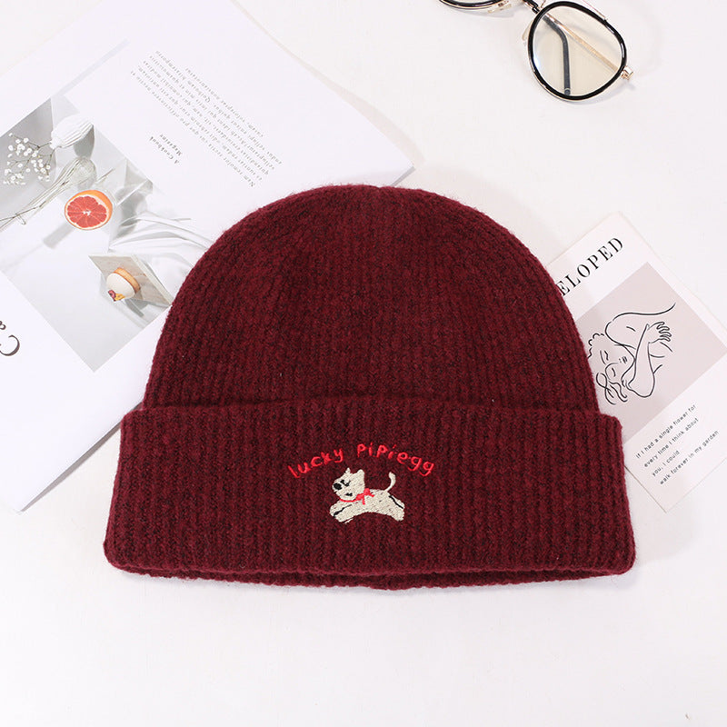 Burgundy winter beanie with Lucky Pipiegg logo against white background
