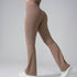 Close-up side view of taupe flared yoga pants with white sneakers, highlighting leg silhouette against gray background