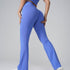 Back view of periwinkle blue flared yoga pants with matching top, highlighting fit against gray background