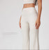 Close-up of cream workout pants with high waistband, 'No awkward lines' text overlay, smooth ribbed texture, seamless construction