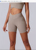 A model is standing wearing beige high-waisted V-cut compression shorts with matching crop top, product dimensions displayed above