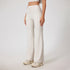 Cream ribbed yoga pants with high waistband, wide leg silhouette, stretchy fabric, cream chunky sneakers, partial crop top visible