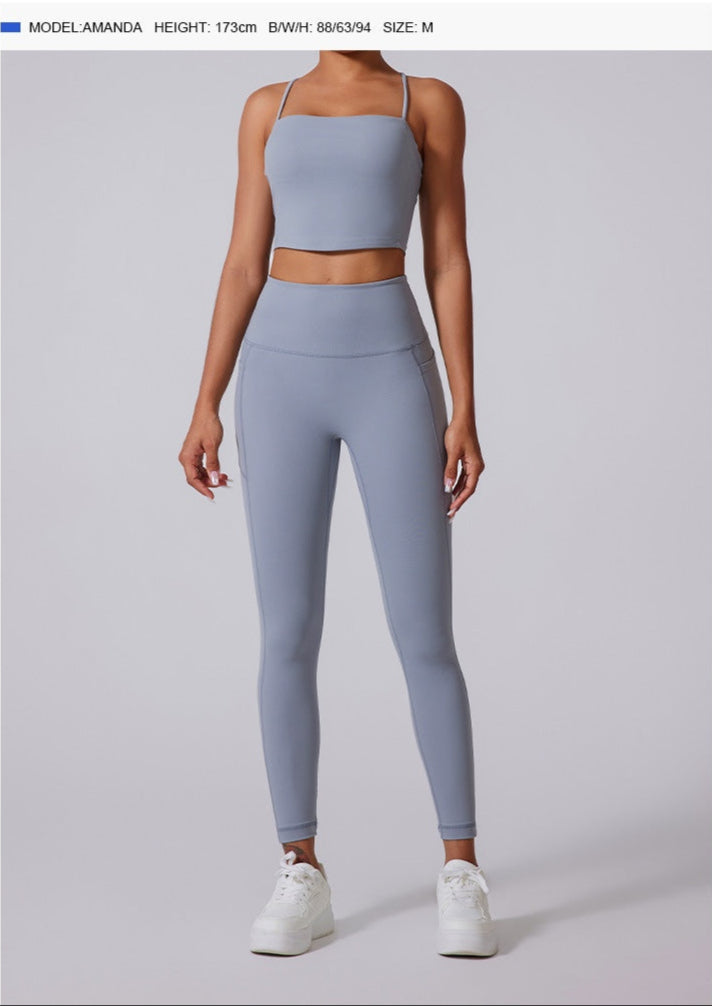 Model wearing powder blue athletic set with high-waisted leggings and tank top, paired with white platform sneakers