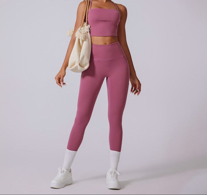 Model in dusty rose workout set with high-waisted leggings, crop top, white sneakers, and cream tote bag