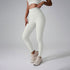 A model wearing off-white high-waisted workout leggings and matching crop top against gray studio background