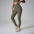 A model wearing olive green high-waisted workout leggings and matching sports bra against gray studio background