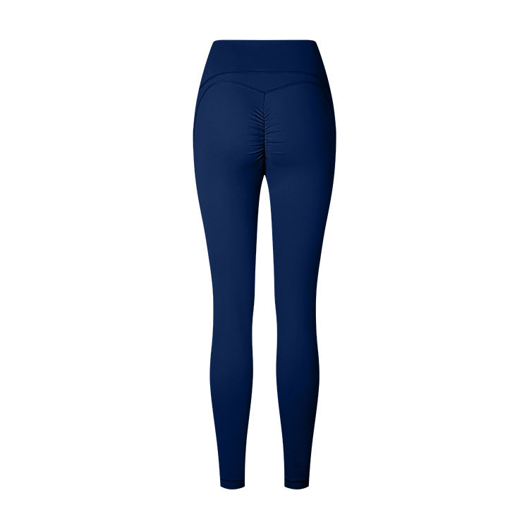 Product photo of navy blue athletic leggings with ruched center seam and high waistband on white background