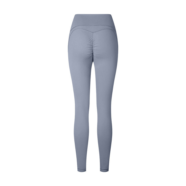 Product photo of light gray athletic leggings with ruched back detail and high waistband on white background