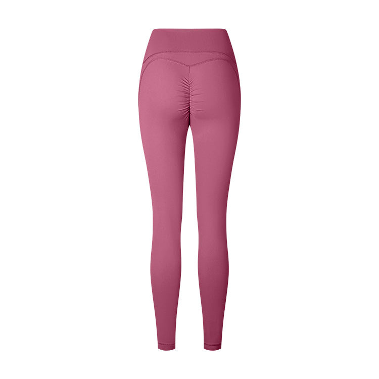 Product photo of dusty rose athletic leggings with ruched back detail, high waistband on white background