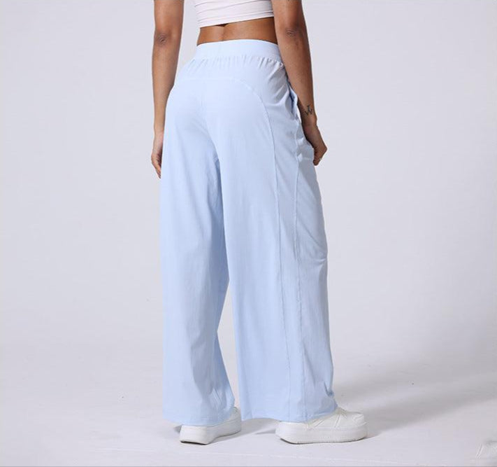 Back view of light blue wide-leg lounge pants with elasticated waistband, paired with white crop top and sneakers
