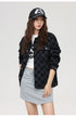 Close-up of black checkered jacket with graphic tee and grey skirt combo