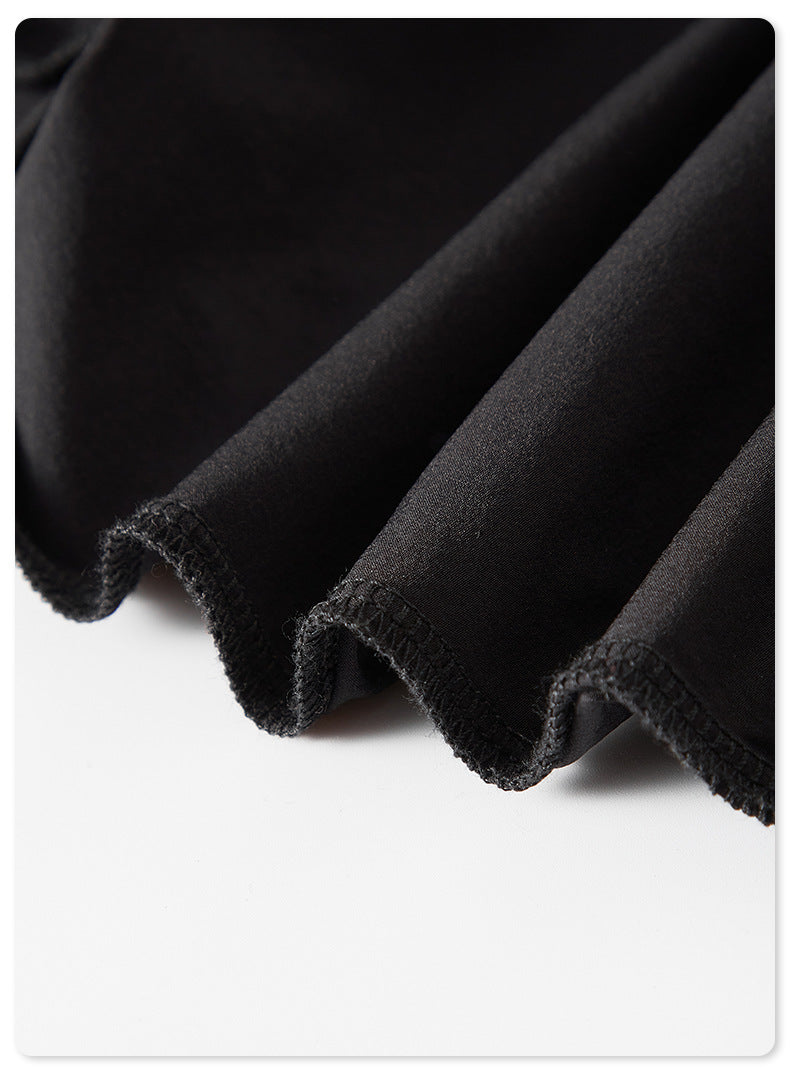 Close-up of black pleated fabric showing hem stitching detail against white background