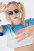 Side view of model with sunglasses, pulling hair and sticking out tongue, wearing blue ombré cropped t-shirt