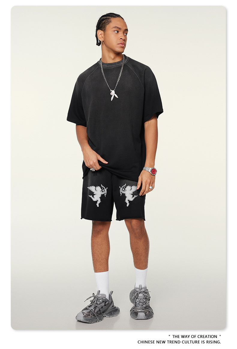 Streetwear outfit with oversized black t-shirt, cupid graphic shorts, silver chain necklace and chunky gray sneakers, styled with cornrow braids