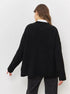 Back view of black ribbed knit sweater showing oversized silhouette and dropped shoulders
