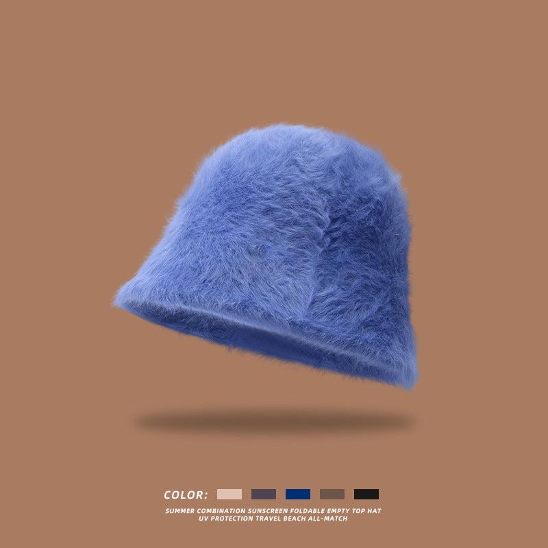 Soft, plush bucket hat in blue without branding, floating on a brown background with available color options below