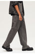 Side profile showing washed black wide-leg jeans paired with platform boots and jean jacket, emphasizing streetwear aesthetic