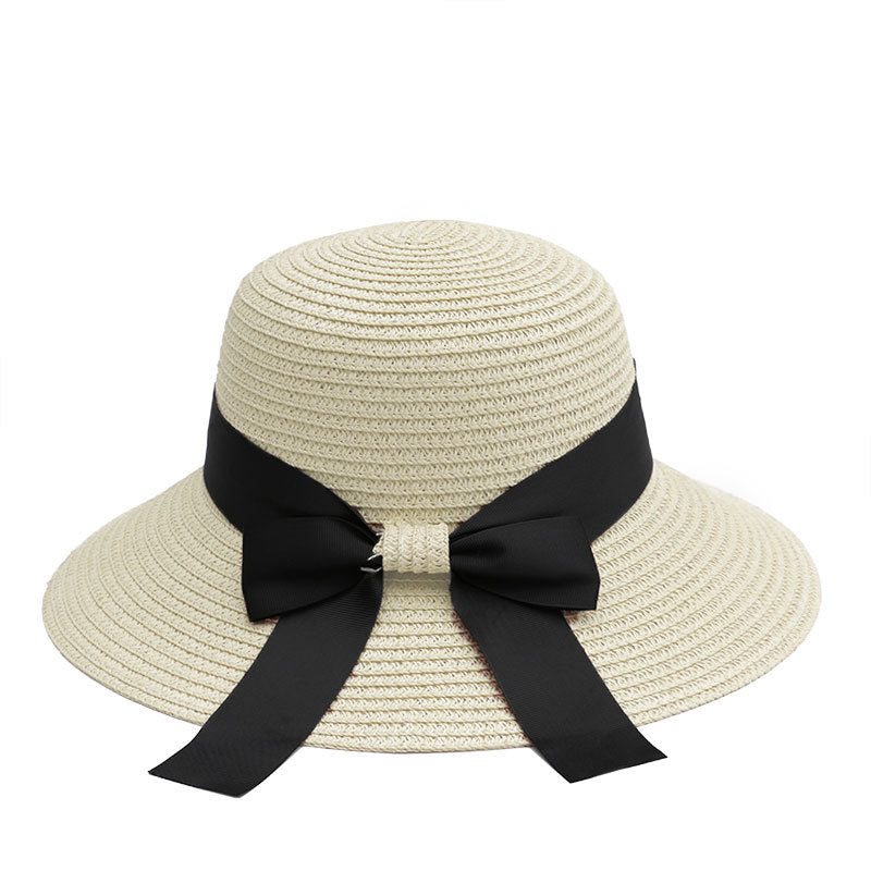 White straw sun hat with a black ribbon bow, designed for a classic and refined summer look.