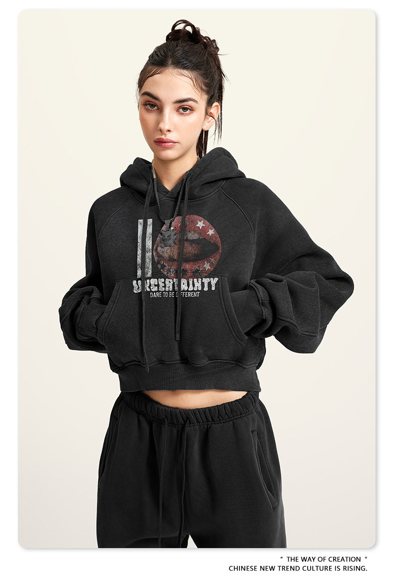 Black cropped hoodie with graphic print, close-up front view