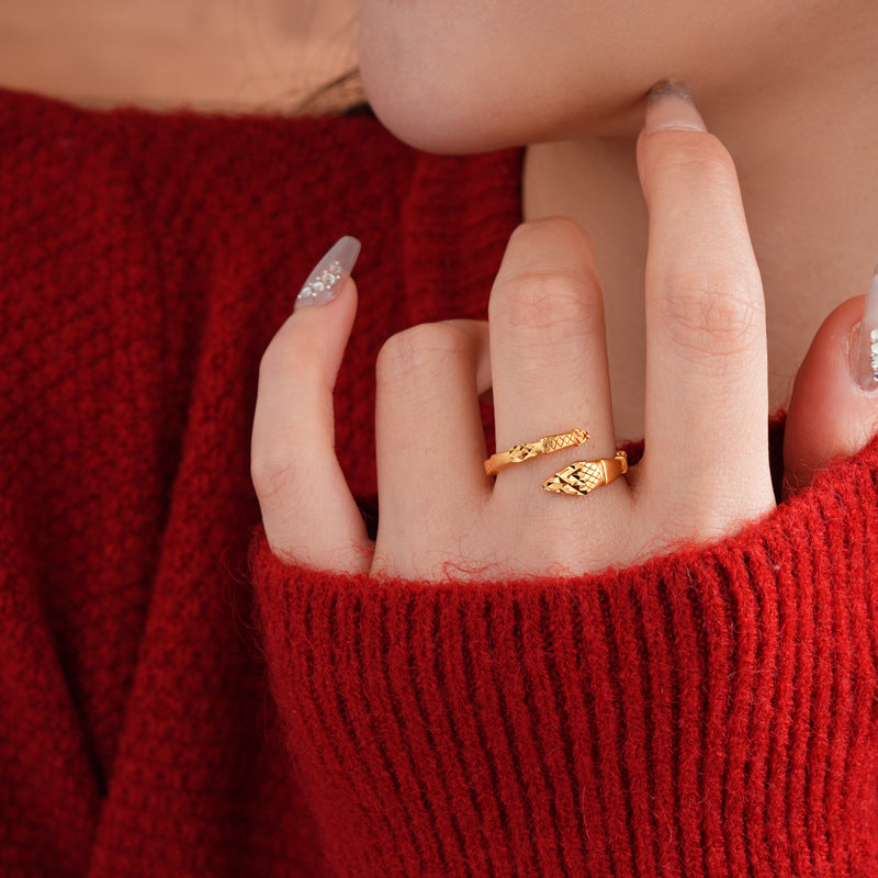 Close-up of adjustable gold snake ring on hand with red sweater