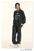 Front view of black 'ERA 07' sweatshirt with distressed print, styled with headphones