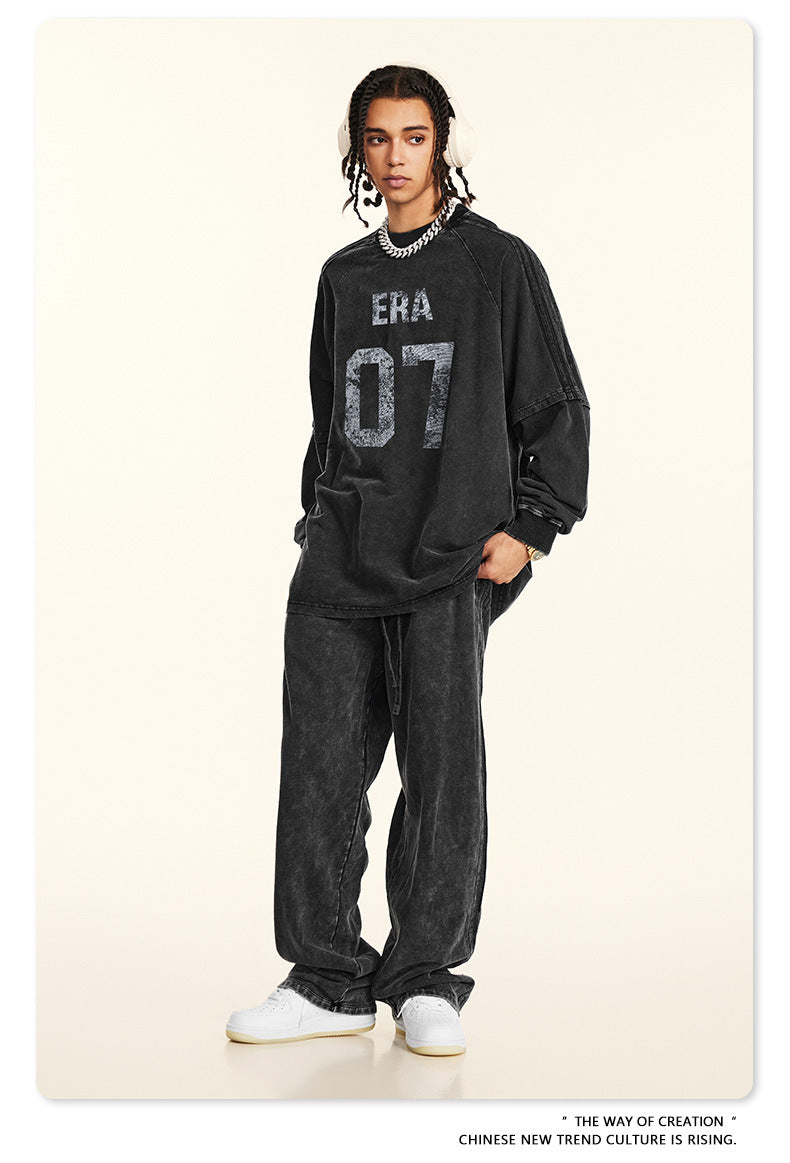 Front view of black 'ERA 07' sweatshirt with distressed print, styled with headphones