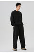 Full-body shot of the black oversized sweatshirt, paired with loose-fitting pants and sneakers for a streetwear look