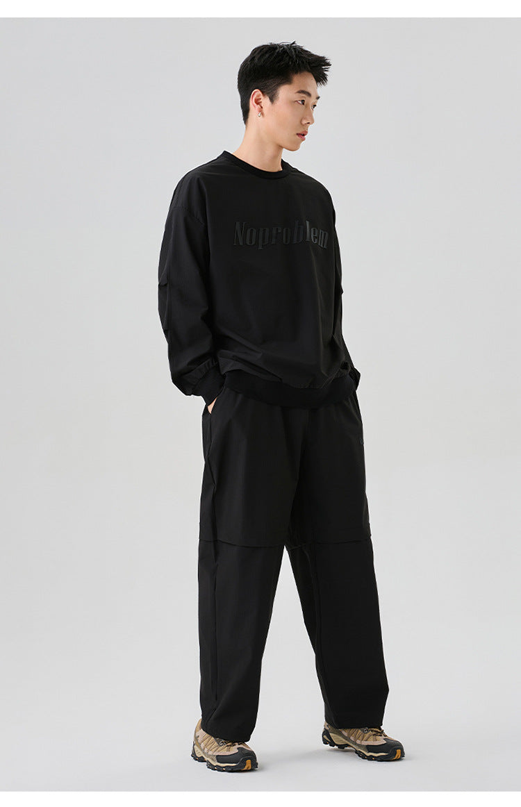 Full-body shot of the black oversized sweatshirt, paired with loose-fitting pants and sneakers for a streetwear look