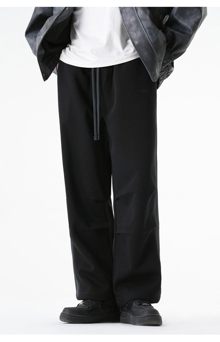 Black wide-leg pants with drawstring waist worn with a white t-shirt and gray leather jacket