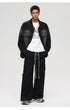 A full-body shot of a male model styling a black gradient denim jacket with wide-leg cargo pants and sneakers