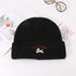 Black ribbed knit beanie featuring white puppy embroidery and red text