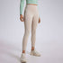 A model in cream colored high-waisted leggings with mint green crop top and matching cream sneakers, studio setting