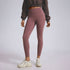 A model wearing mauve high-waisted leggings, brown cropped sweatshirt, and cream chunky sneakers, photographed against gray backdrop