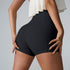 Close-up rear view of black high-waisted athletic shorts with cream ruffle top, showing seamless compression fit