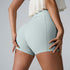 Close-up rear view of light blue athletic shorts with white ruffle top, showing compression fit