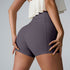 Close-up rear view of charcoal gray athletic shorts with cream ruffle top, displaying seamless design
