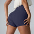 Close-up rear view of navy blue athletic shorts with ivory ruffle top, showcasing compression fit