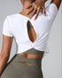 Back view of white t-shirt with twist detail and cutout showing tattoo, paired with olive leggings with side cutouts