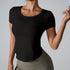 Woman in black fitted scoop neck t-shirt with curved hem paired with olive high-waisted leggings against gray background